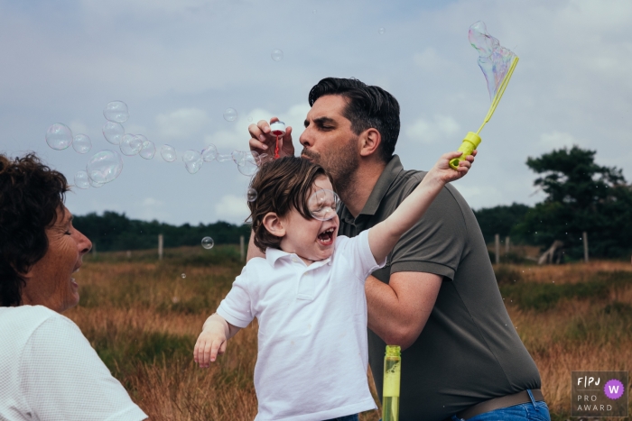 Familienshooting in Amsterdam mit Oma, Vater und Sohn, die mit Seifenblasen spielen