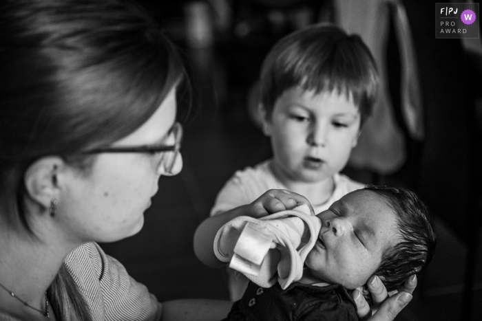 Savoie Familienfotografie eines kleinen Jungen, der dem Baby den Mund abwischt