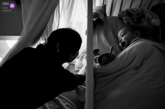 Flanders day in the life photo of a mother tucking in her sweet baby to bed for the night Flanders day in the life photo of a mother tucking in her sweet baby to bed for the night