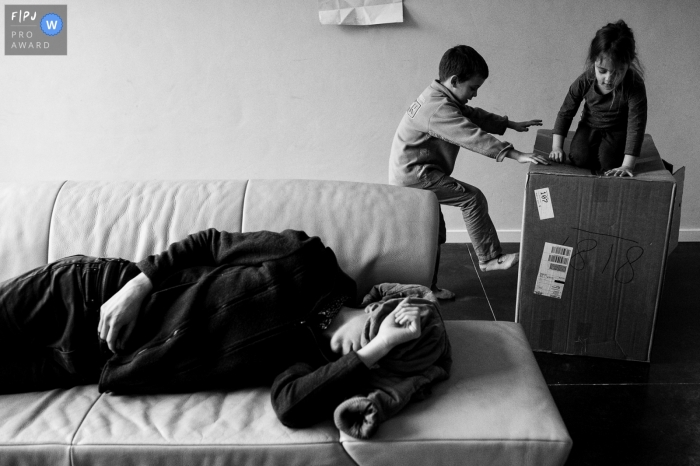 East Flanders day in the life photo of children playing in a box while a resting parent trying to get in a nap