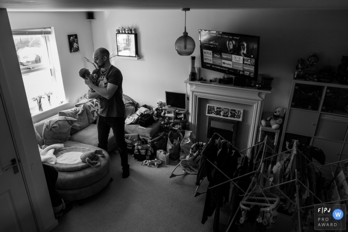 Bath family photo shoot of a father holding his new baby daughter