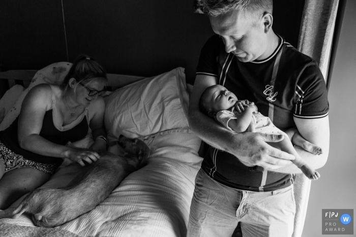 Somerset family shoot showing a father as he holds his baby daughter while Mother strokes dog Somerset family shoot showing a father as he holds his baby daughter while Mother strokes dog