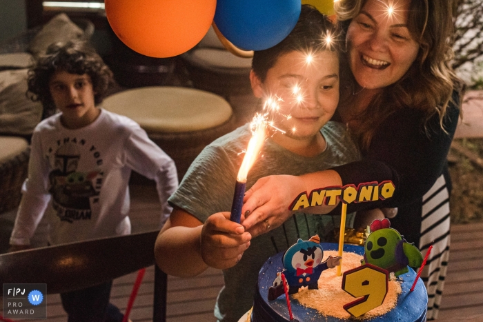 Photographie de fête d'anniversaire de la famille Campo Grande d'un garçon célébrant avec un gâteau et une bougie