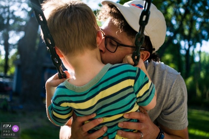 Atlanta backyard family shoot of a father kissing his son on the swing Atlanta backyard family shoot of a father kissing his son on the swing