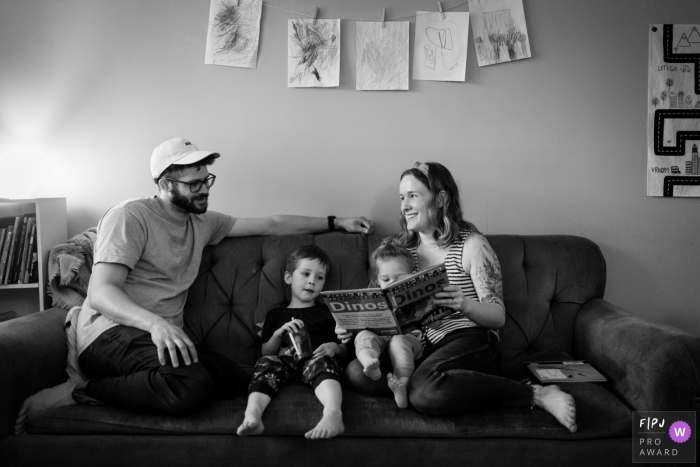 Atlanta Family lit un livre sur le canapé ensemble lors de cette séance photo à domicile