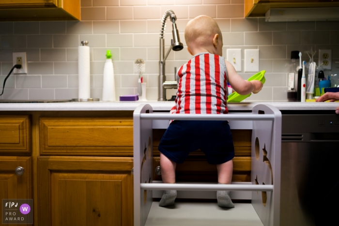 Atlanta at-home photo of a baby boy washing dishes in the sink Atlanta at-home photo of a baby boy washing dishes in the sink