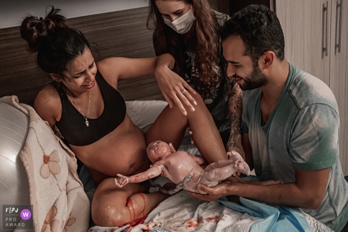 A Sao Paulo documentary birth photographer chronicled a Baby being welcomed by his father and given to his mother after birth