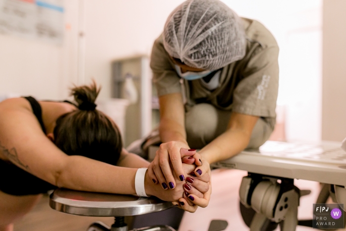 Un photographe de naissance documentaire de Sao Paulo à l'hôpital e Maternidade São Luiz a capturé une mère en train d'avoir un bébé et d'obtenir du soutien