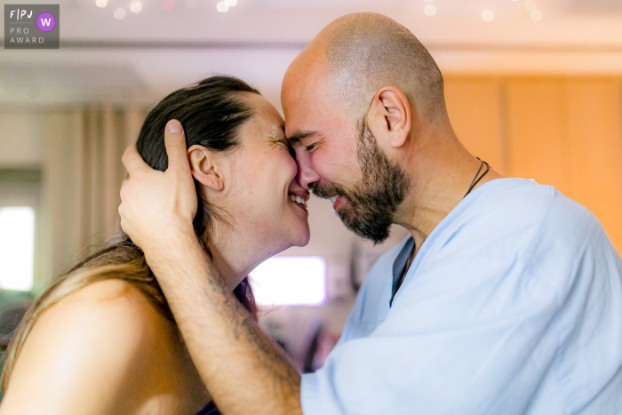 A Sao Paulo, Brazil birth photographer at Maternidade Pro Matre documented this dad hugging mom during birthing session