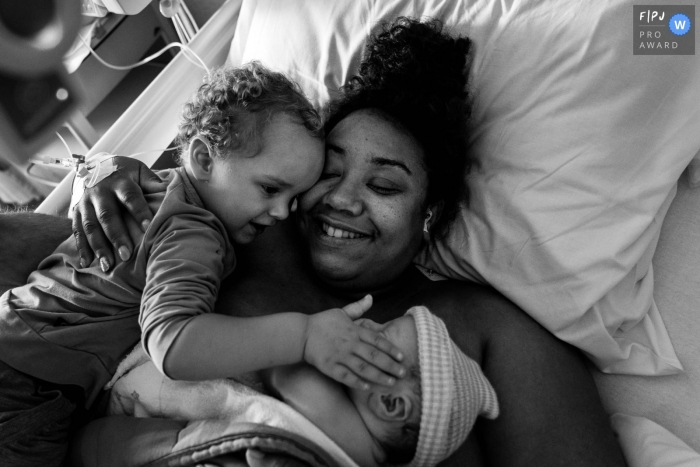 Photo by: <a href="https://www.fpja.com/documentary-family-photography-contests/marjolein-roossien/groningen/2115903">Marjolein Roossien - Netherlands</a> Groningen, Netherlands birth photography of a big siblings Love at first sight for new baby sibling