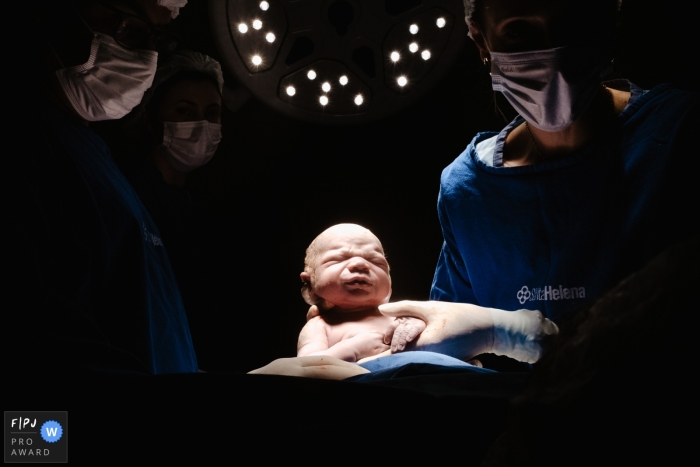 Ein Geburtsfotograf aus Florianopolis in Maternidade Santa Helena dokumentierte dieses Baby bei der Geburt unter den Lichtern des Kreißsaals des Krankenhauses