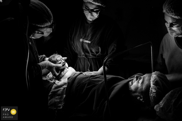 Photo by: <a href="https://www.fpja.com/documentary-family-photography-contests/thiago-braga/florianopolis/2116338">Thiago Braga - Brazil</a> Florianpolis birth photography at Maternidade Santa Helena documenting the Birth of a baby by cesarean delivery, with the child being seen by its mother at the exact moment it comes out of the womb