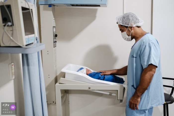 Photographie documentaire de la naissance de Santa Catarina à Maternidade Santa Helena d'un père regardant son nouveau-né dans le berceau de la maternité