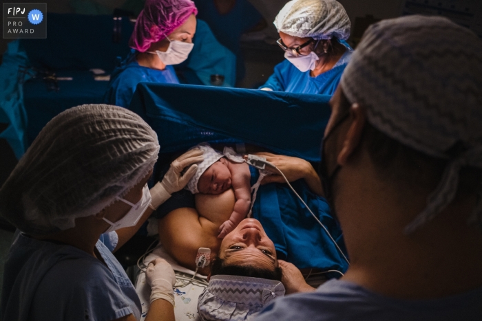 Ein dokumentarischer Geburtsfotograf aus Sao Paulo, Brasilien, hat diese schöne und respektvolle Umarmung und Berührung für das neue Baby aufgenommen