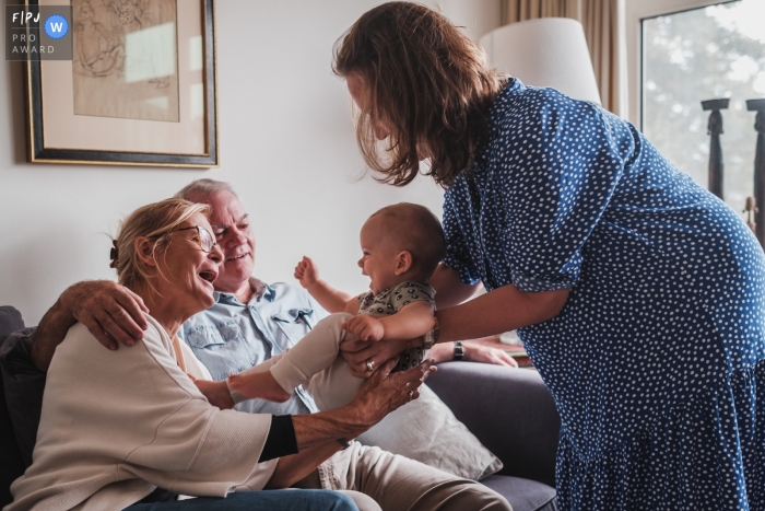 An Antwerpen documentary family photographer recorded a Daughter smiling as she is given to her grandparents