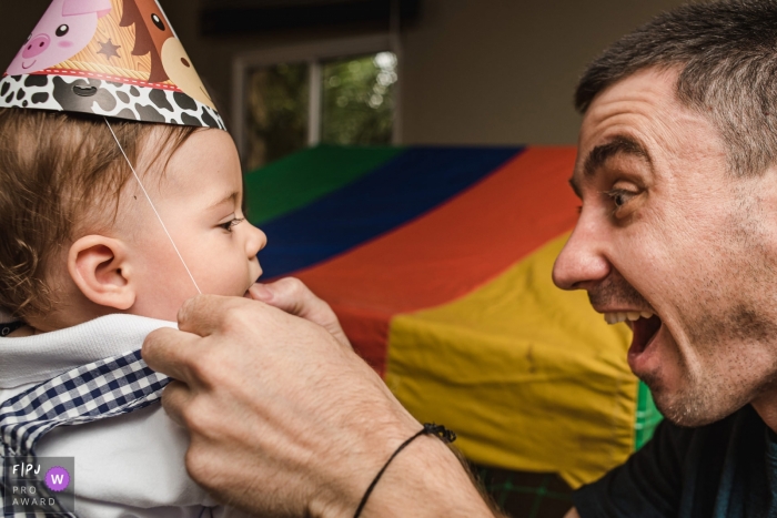 Photo by: <a href="https://www.fpja.com/documentary-family-photography-contests/roberto-sim%C3%B5es/campo-grande/2115387">Roberto Simões - Brazil</a> A Mato Grosso do Sul documentary family photographer captured The uncle putting a party hat on the birthday boy
