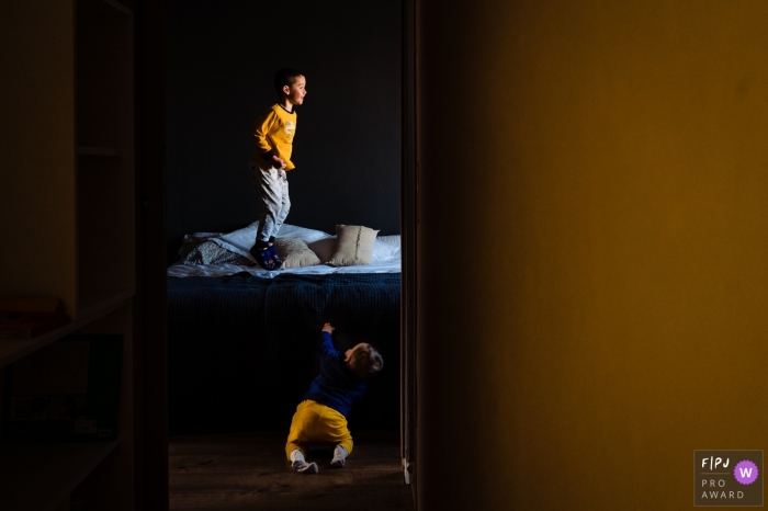 Perpignan family photography documenting Yellow kids playing on a bed in the bedroom at home