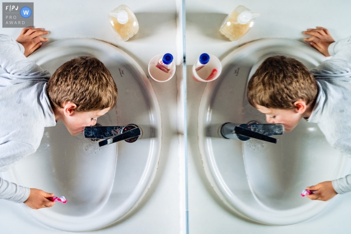 Photo by: <a href="https://www.fpja.com/documentary-family-photography-contests/olivier-bolte/perpignan/2115529">Olivier Bolte - France</a> Perpignan documentary family photography showing a Double tooth wash in the bathroom sink while brushing teeth