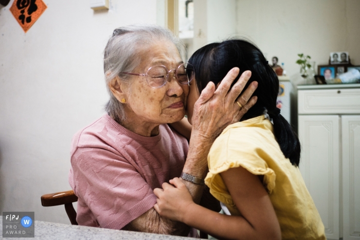 Hong Kong dokumentarische Familienfotografie von Ein Abschiedskuss für Oma am Ende eines wöchentlichen Besuchs