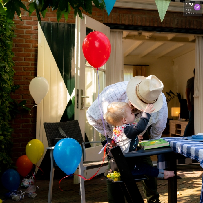 Un photographe de famille documentaire de Zuid Holland a enregistré ce tout-petit saluant son grand-père lors d'une fête en plein air avec des ballons