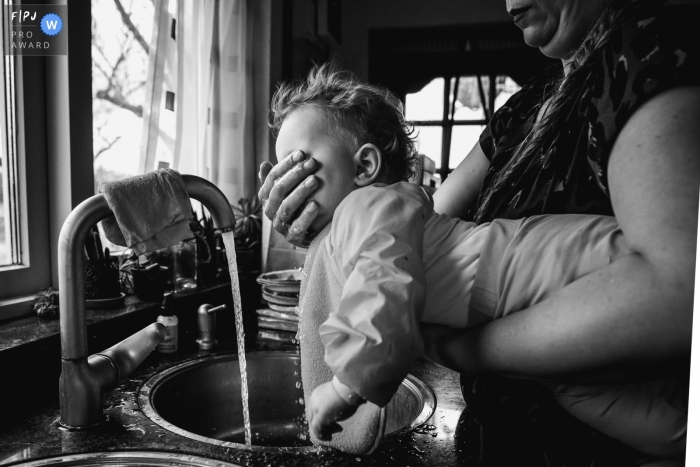 Un photographe de famille documentaire en Hollande-Méridionale, aux Pays-Bas, a relaté cette mère nettoyant le visage de son bébé