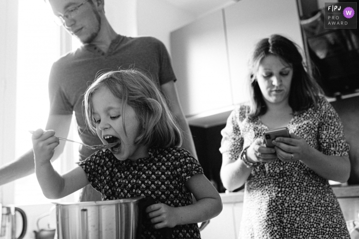 Un photographe de famille documentaire à Paris, en France, a capturé cette famille alors qu'elle prépare des crêpes dans la cuisine