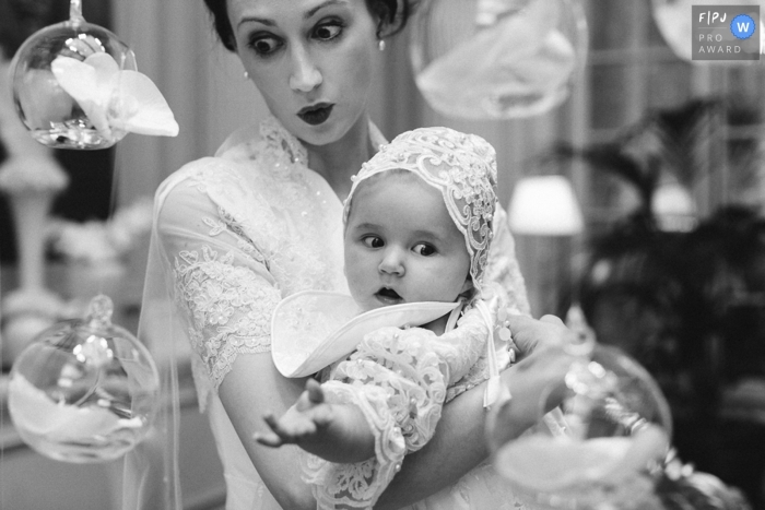 Photo by: <a href="https://www.fpja.com/documentary-family-photography-contests/marine-poron/paris/2115982">Marine Poron - France</a> A Paris documentary family baptism photographer chronicled this mom and baby at baptism in Black and White