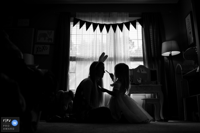 An Atlanta, Georgia family photographer captured a Daughter applying makeup to her mother in silhouette