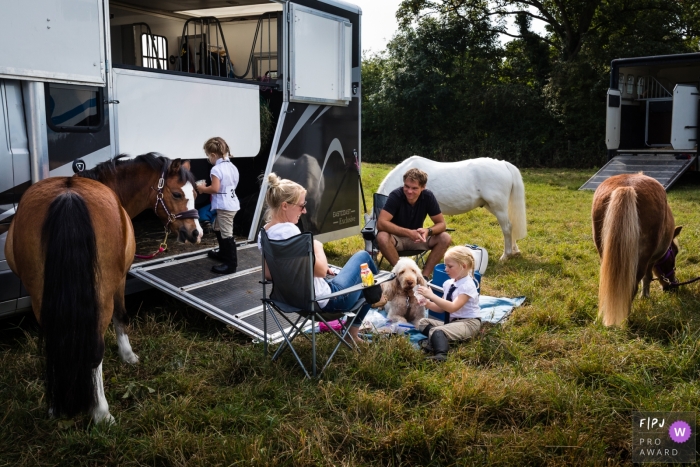 Photographie de famille documentaire du Cambridgeshire montrant une famille se détend entre les événements d'un spectacle équestre