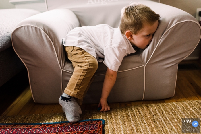 Photo by: <a href="https://www.fpja.com/documentary-family-photography-contests/laurie-peacock/chicago/2116207">Laurie Peacock - United States</a> A Chicago documentary family photographer chronicled this boy sitting in a small chair at home and is totally over it