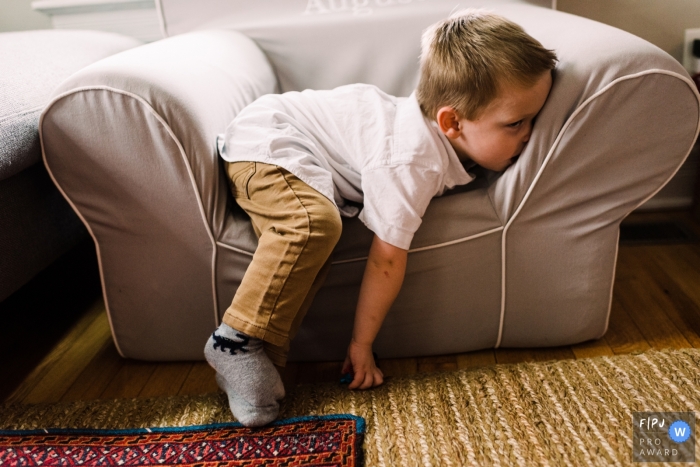 A Chicago documentary family photographer chronicled this boy sitting in a small chair at home and is totally over it