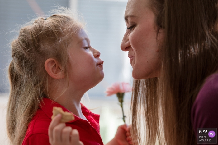 A San Francisco family photographer documented this mom kissing her little girl with the little girl having a mouth full of cookie A San Francisco family photographer documented this mom kissing her little girl with the little girl having a mouth full of cookie