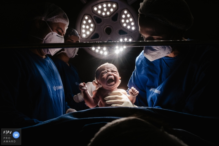 Das preisgekrönte Geburtsfoto von Santa Catarina in der Maternidade Santa Helena, das während einer Geburt per Kaiserschnitt mit dem Baby zwischen den Lichtern auf der Entbindungsstation erstellt wurde