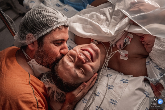 Awarded documentary style birth image from Sao Luiz Anália Franco in Sao Paulo of Happy parents welcoming their child