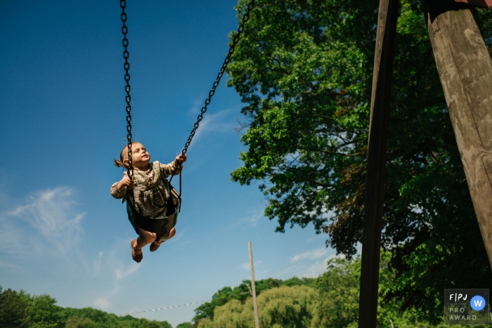 Awarded documentary family picture from Kingston, ON of a little girl carefree on a swing Awarded documentary family picture from Kingston, ON of a little girl carefree on a swing