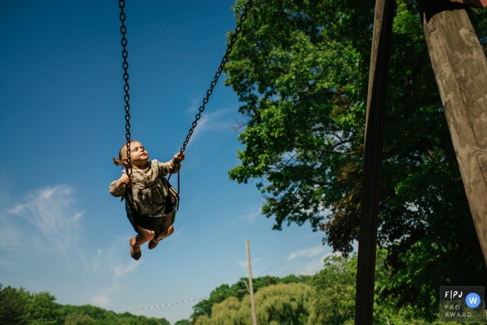 Awarded documentary family picture from Kingston, ON of a little girl carefree on a swing