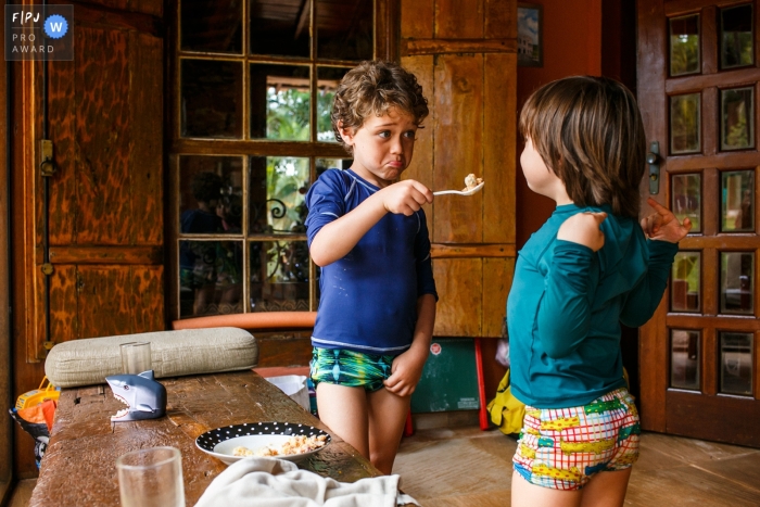 Dokumentarfilm-Fotosession der Familie Belo Horizonte, die den komischen Gesichtsausdruck des älteren Cousins ​​zeigt, wenn er versucht, den jüngeren zu füttern