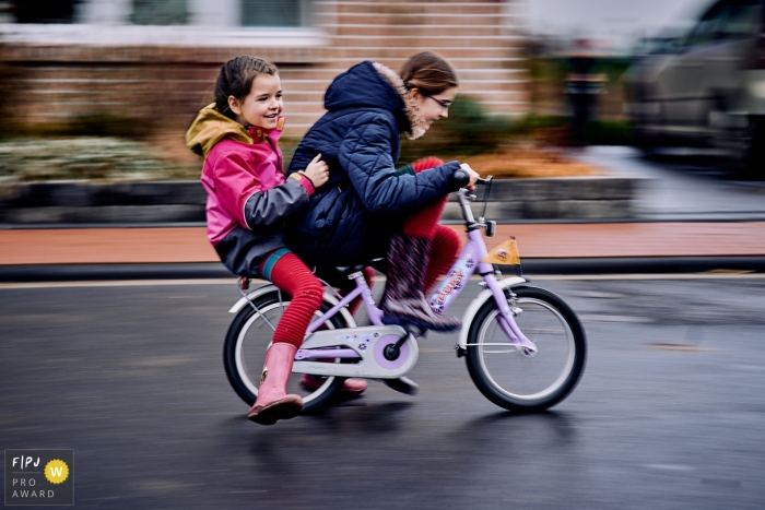 Awarded documentary family show shutter image from North Rhine-Westphalia of Sisters going wild in the streets on a bike Awarded documentary family show shutter image from North Rhine-Westphalia of Sisters going wild in the streets on a bike