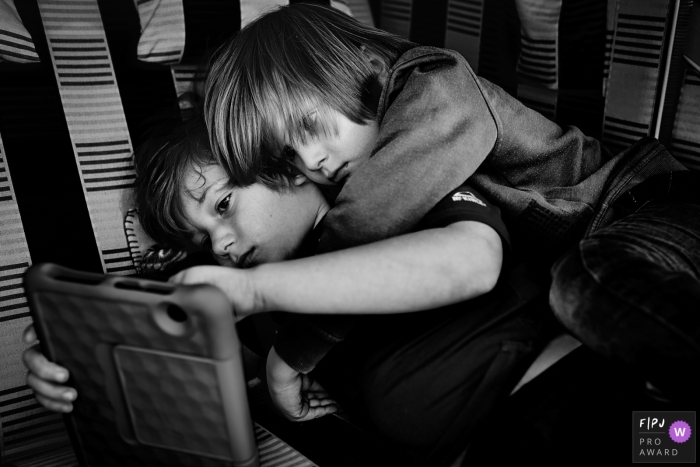 Bonn familie documentaire fotografiesessie in BW met Brothers op elektronisch apparaat