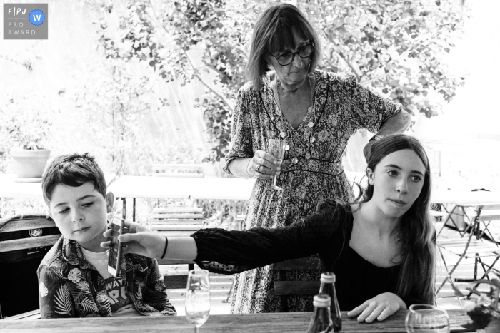 Awarded documentary family photo from Paris in BW of a teen and phone with brother Awarded documentary family photo from Paris in BW of a teen and phone with brother