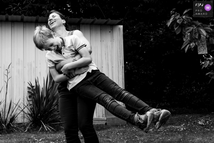 Paris family documentary photography session showing kids with the apple Documentary Paris family photography in BW showing games with mom during outdoor photoshoot