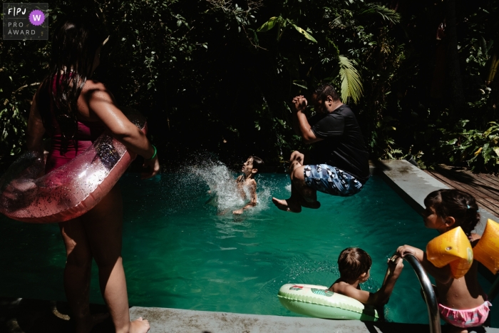 Documentaire Santa Catarina-familiefotografie waarin kinderen en volwassenen springen en zwemmen in het zwembad op een verjaardagsdag