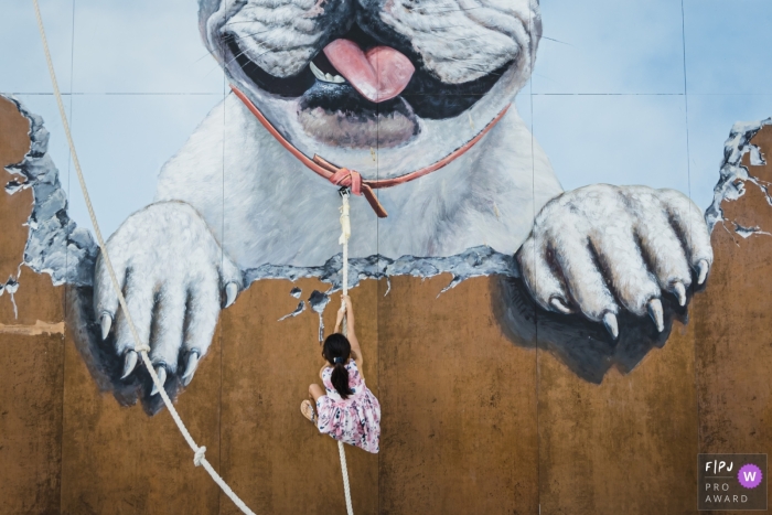 Awarded documentary family image from Dubai, UAE of a child Climbing a wall with a rope