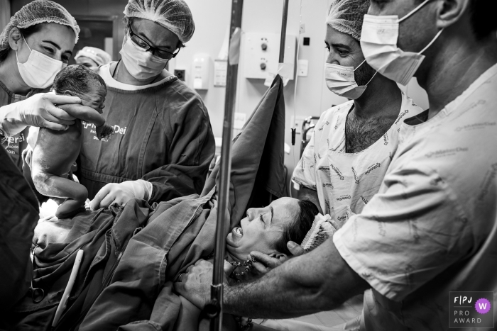 De emotie van de ouders om hun dochter na de geboorte te zien in deze bekroonde Belo Horizonte geboortefotografie in Mater Dei