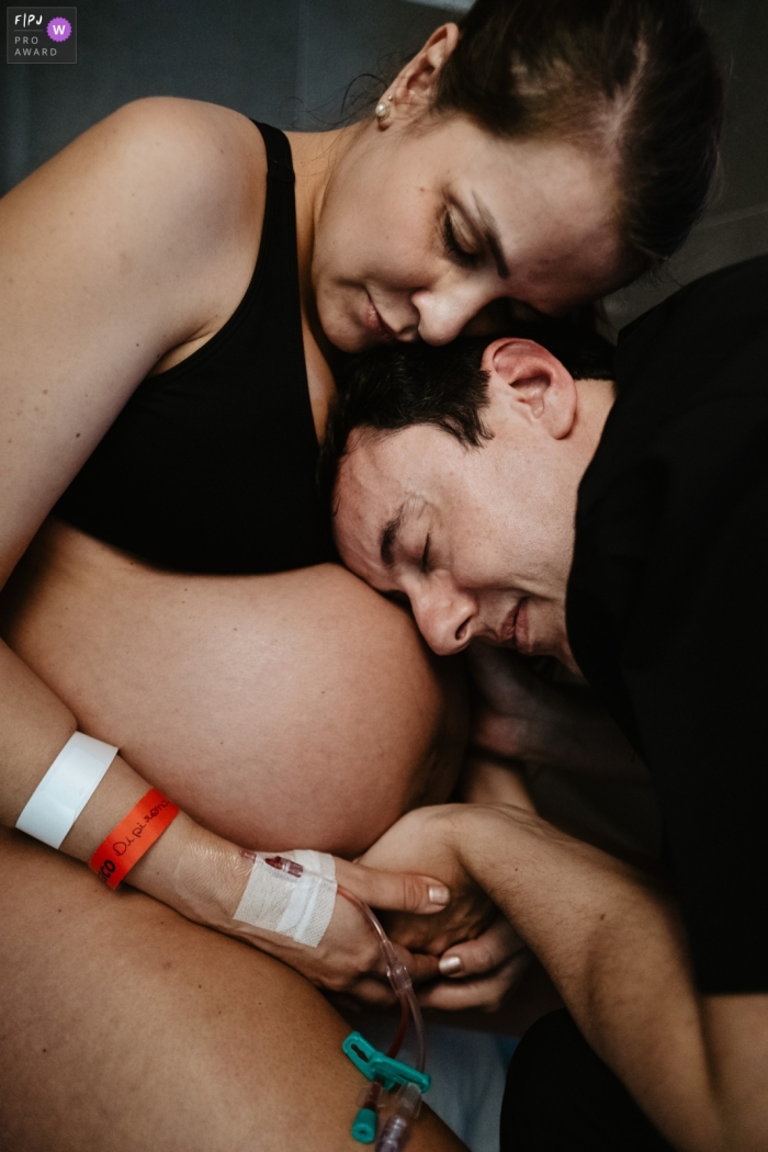 Photo de naissance documentaire de Santa Catarina à Maternidade Santa Helena enregistrant le père étreignant le ventre de la mère, avec un geste d'affection, pendant le travail