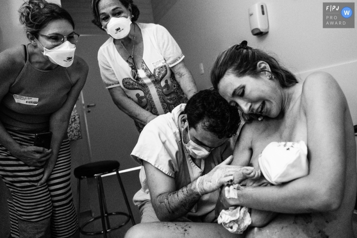 Photographie de naissance primée à Sao Paulo capturant des grands-parents regardant leurs enfants excités après la naissance de leur petite-fille