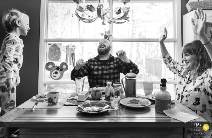 Atlanta best documentary family picture from a home session in Georgia created when the small boy cracks up his parents while they are singing a song at the breakfast table