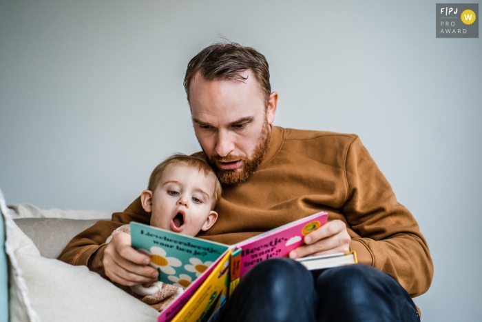 Limburg documentary style photography from a family session while dad is reading a book Limburg documentary style photography from a family session while dad is reading a book