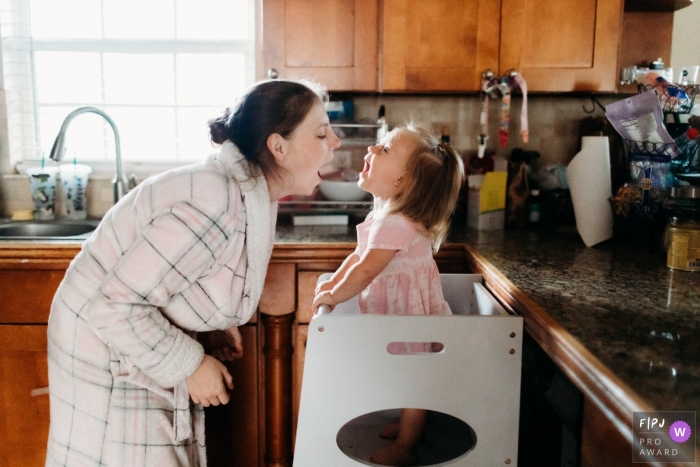 A little girls is Cooking with mommy during a documentary family photography session at a home in the Azores A little girls is Cooking with mommy during a documentary family photography session at a home in the Azores