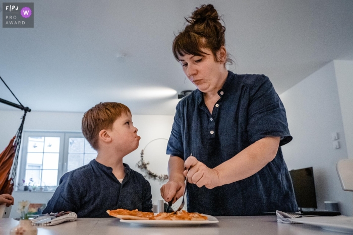 Documentary family photojournalism from Dusseldorf captured a young boy mad at mom for cutting his food Documentary family photojournalism from Dusseldorf captured a young boy mad at mom for cutting his food
